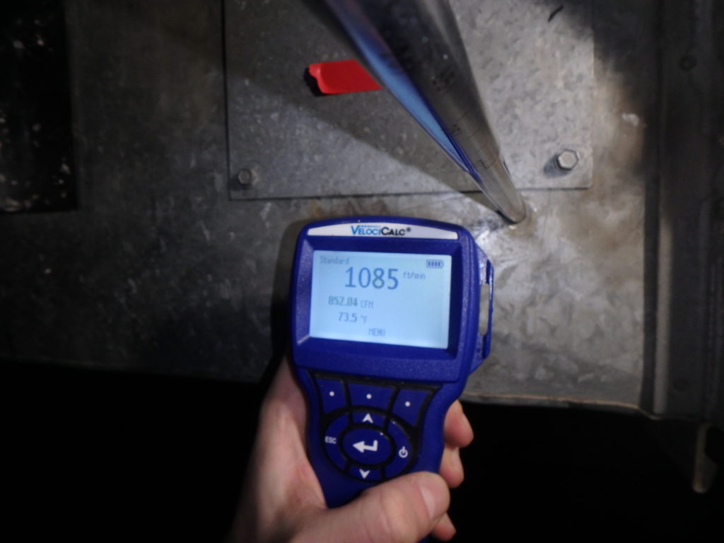 flow meter held by a person in a mechanical room